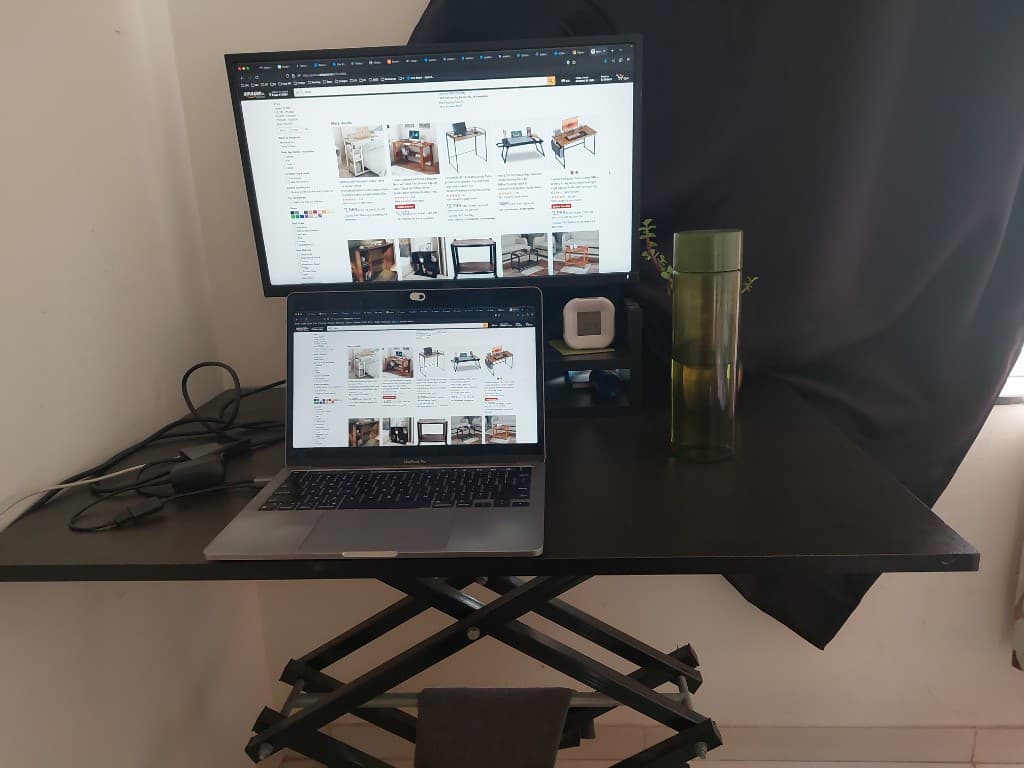 Home desk with MacBook and external monitor on a standing desk converter